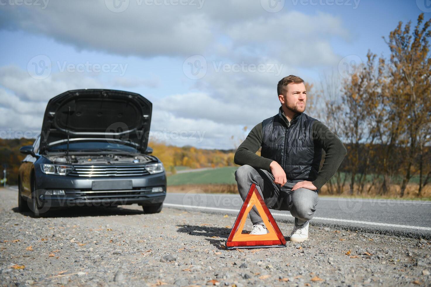 Man with broken car in the middle of the road. photo