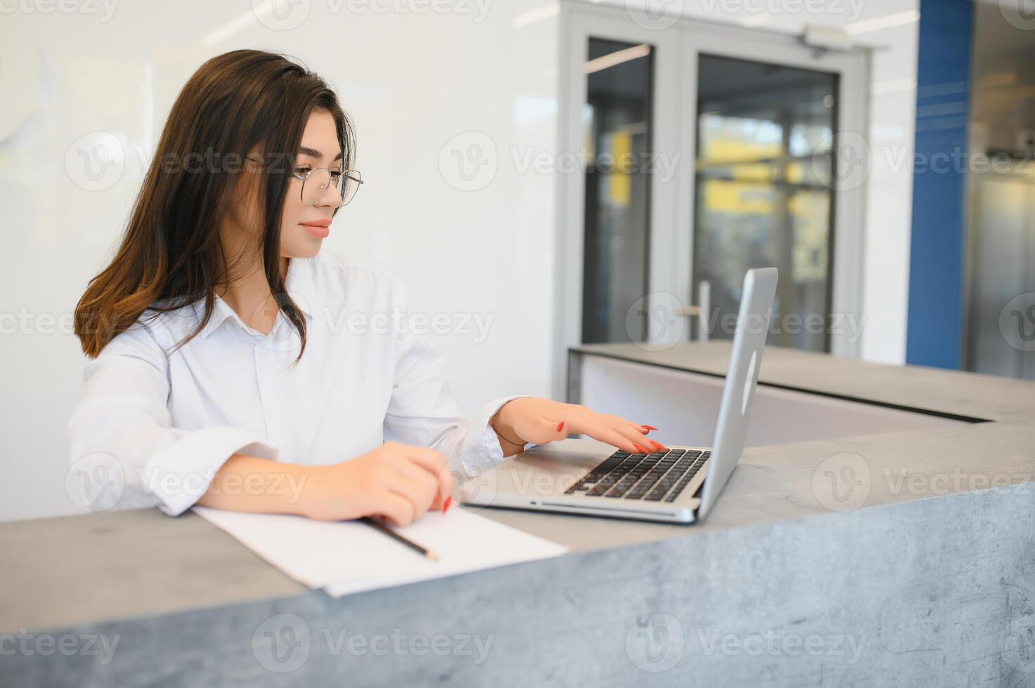Portrait of receptionist at desk in lobby photo