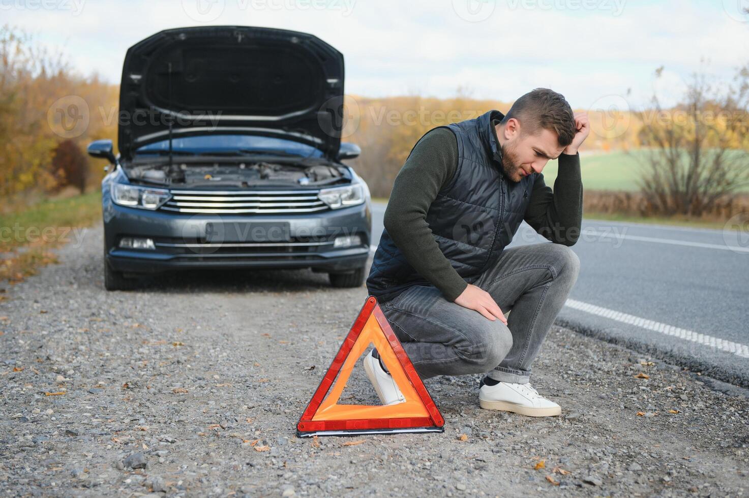 Man with broken car in the middle of the road. photo