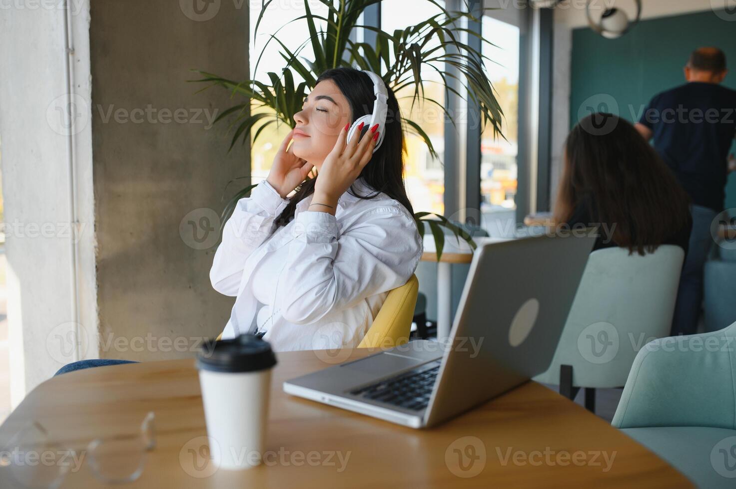 Beautiful Young Freelancer Woman Using Laptop Computer Sitting At Cafe Table. Happy Smiling Girl Working Online Or Studying And Learning While Using Notebook. Freelance Work, Business People Concept. photo