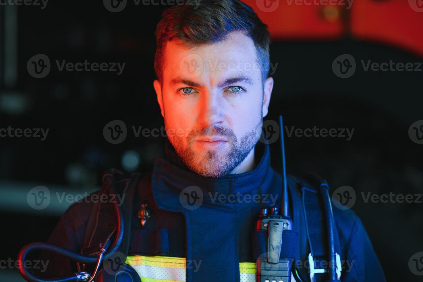 Fireman firefighter in action standing near a firetruck. Emergency safety. Protection, rescue from danger. photo