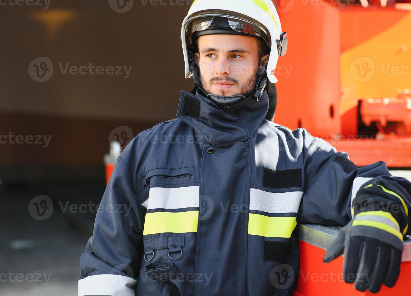 Firefighter portrait on duty. Photo fireman with gas mask and helmet near fire engine.
