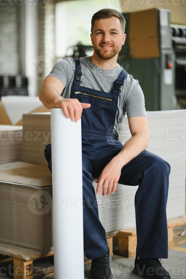 Funny portrait of typographer standing with color swatches at the printing manufacturing photo