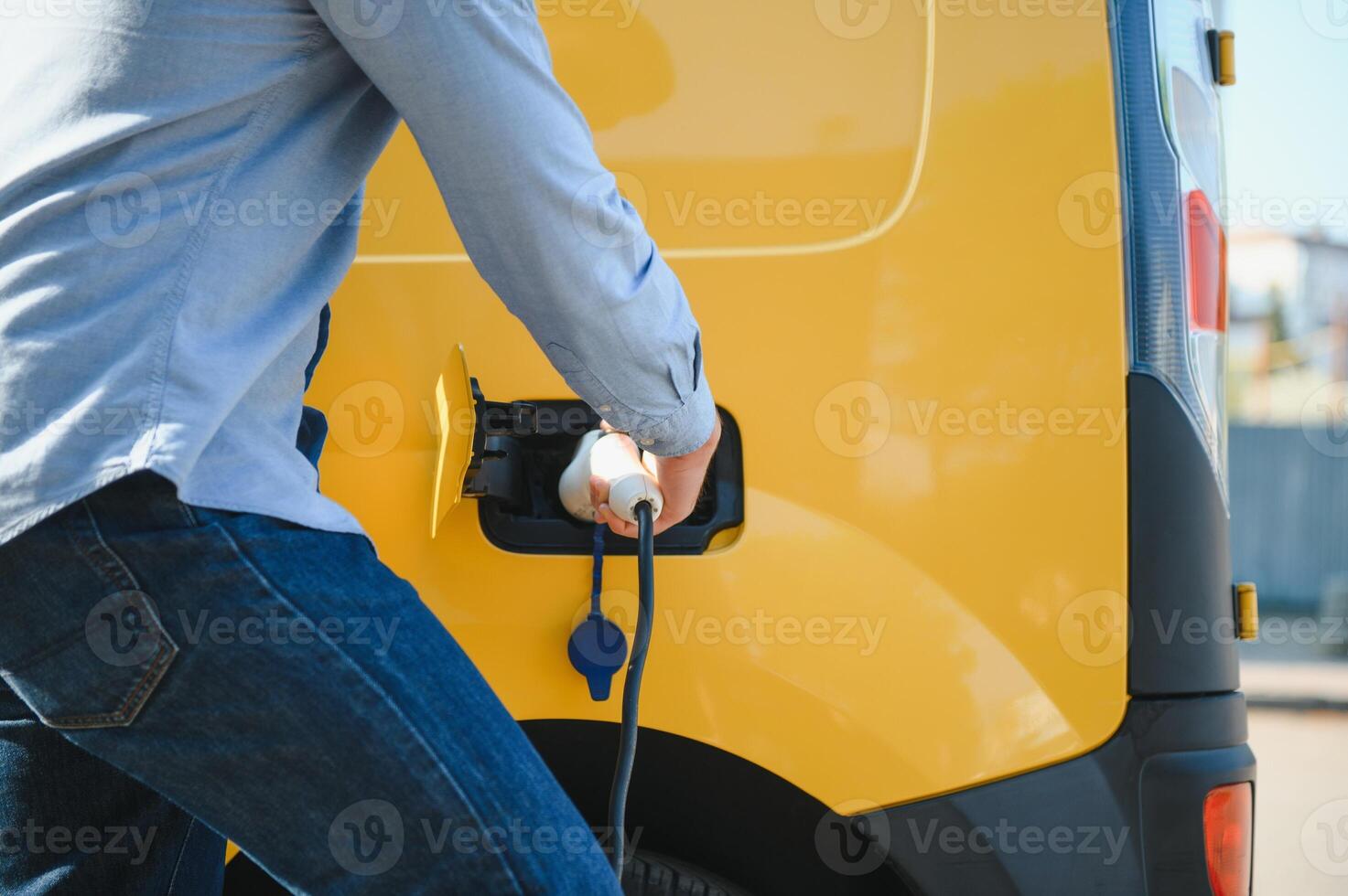 Smiling man unplugging the charger from the car photo