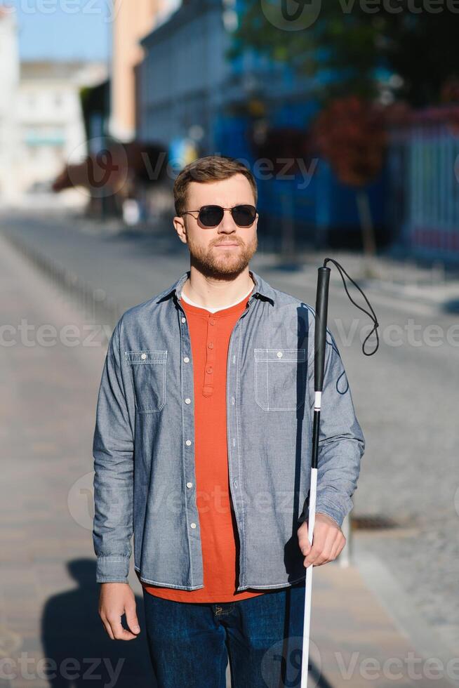 Blind man. People with disability, handicapped person and everyday life. Visually impaired man with walking stick. photo