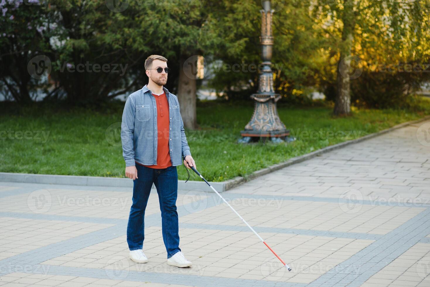 Blind man. People with disability, handicapped person and everyday life. Visually impaired man with walking stick. photo