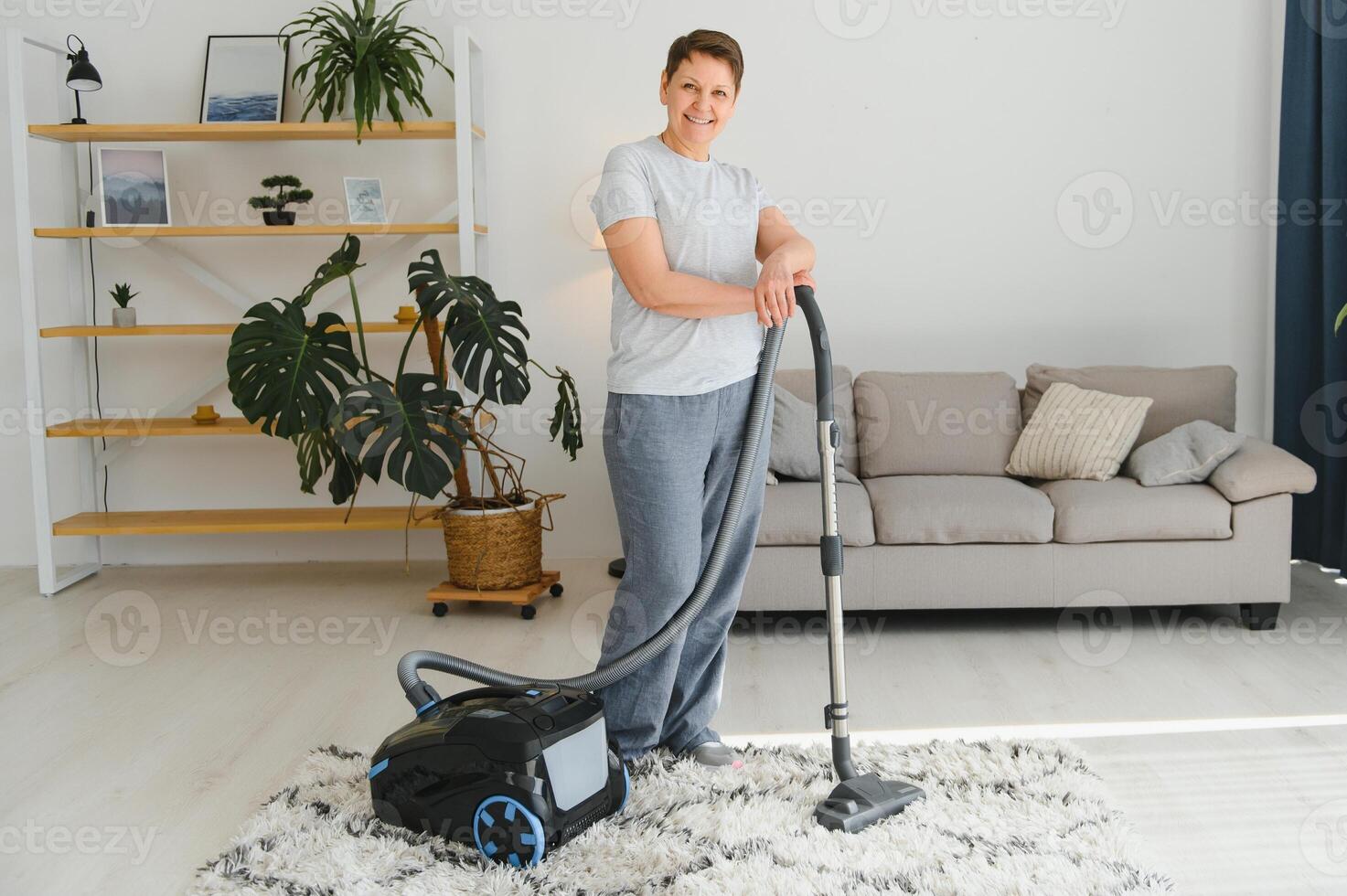 Middle-aged woman cleaning new apartment. photo