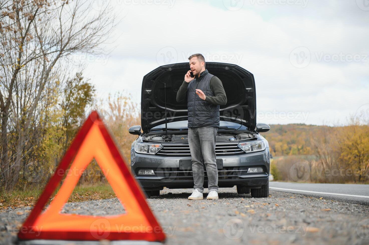 Man with broken car in the middle of the road. photo