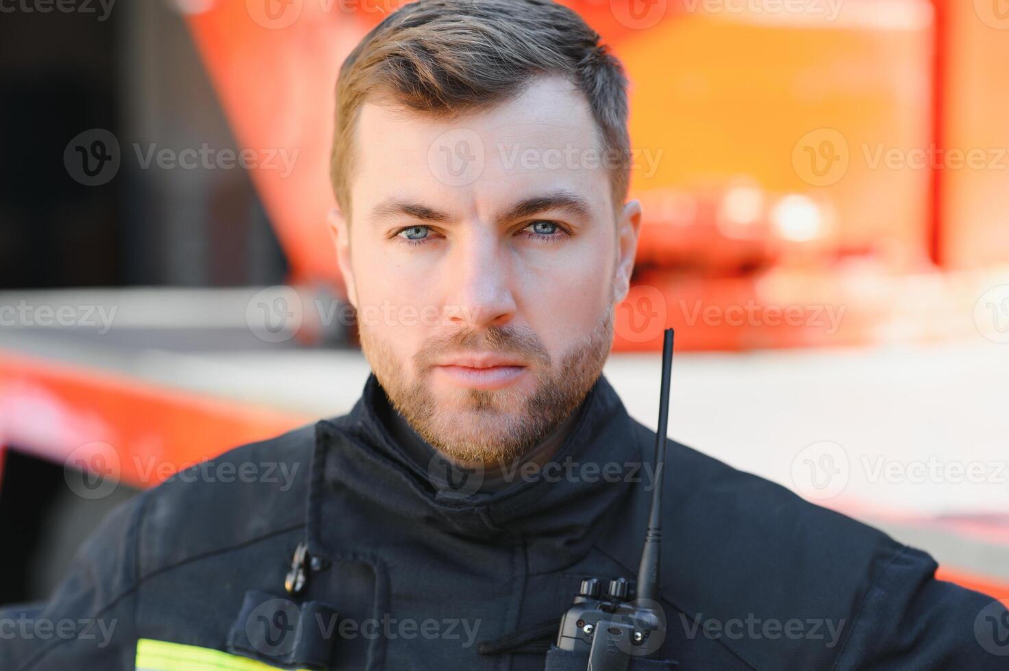 Fireman firefighter in action standing near a firetruck. Emergency safety. Protection, rescue from danger. photo
