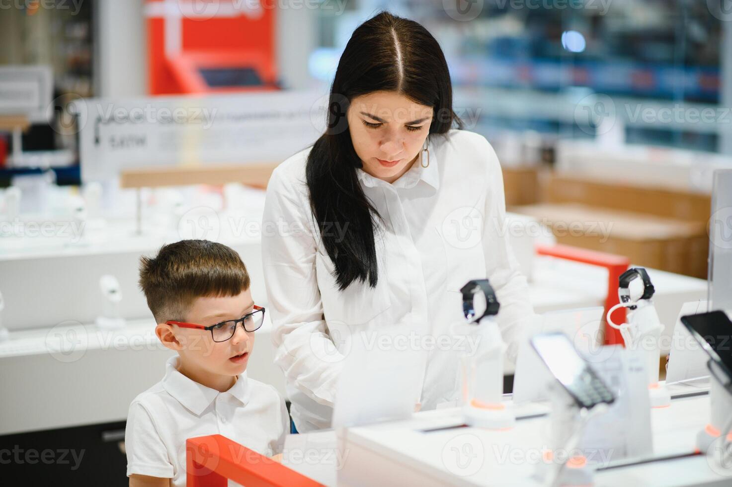 Beautiful young woman choosing which smart phone to buy. Shopping in tech store. photo