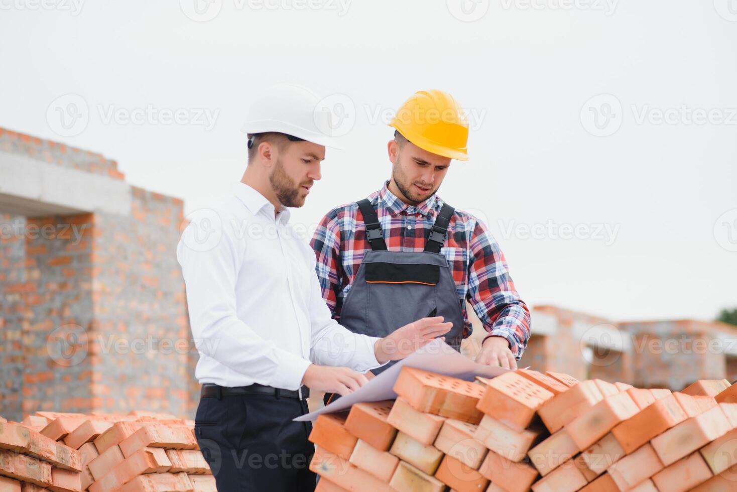 ingeniero arquitecto con difícil sombrero y la seguridad chaleco trabajando juntos en equipo en mayor construcción sitio foto