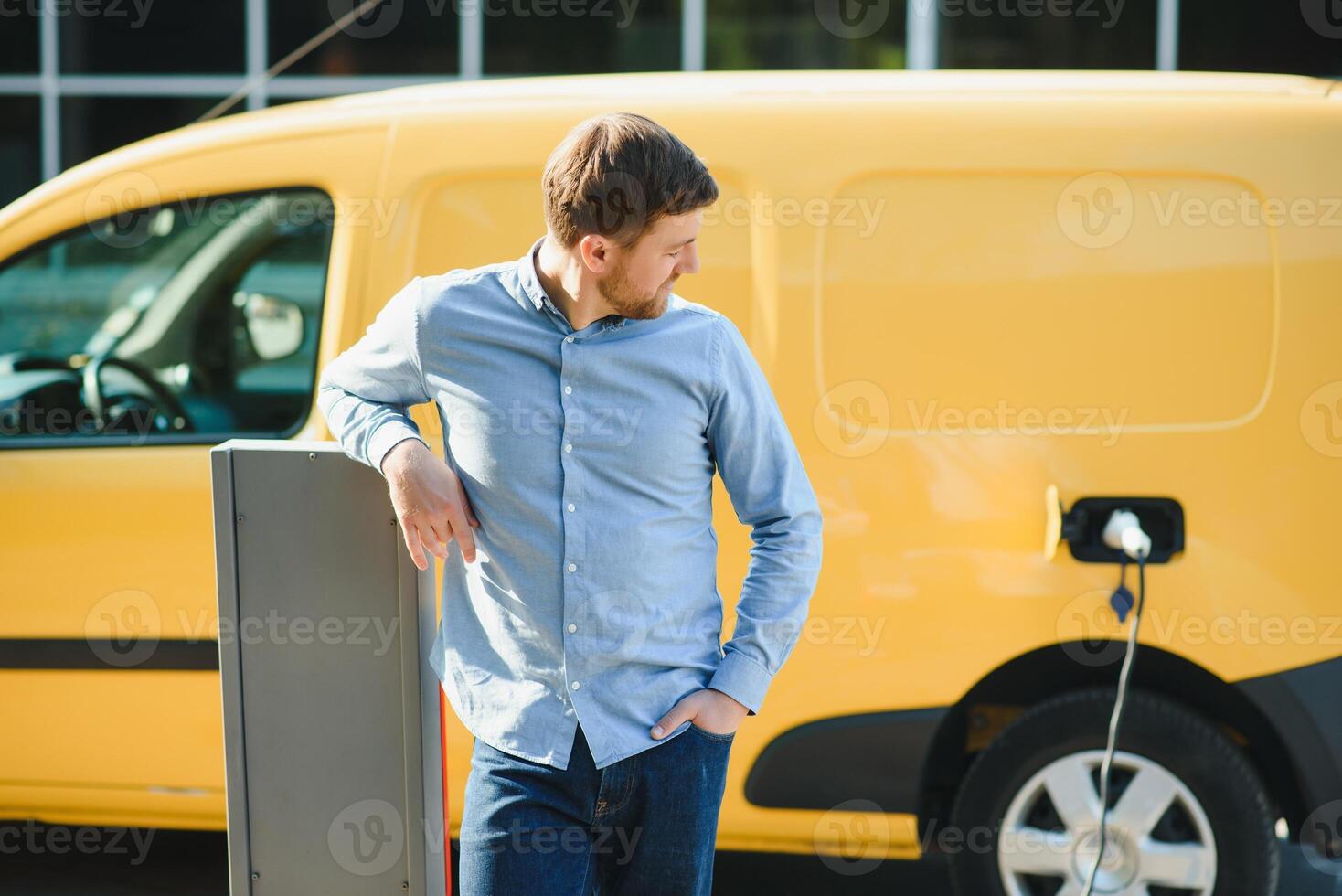 Man charging his electric car at charge station. photo