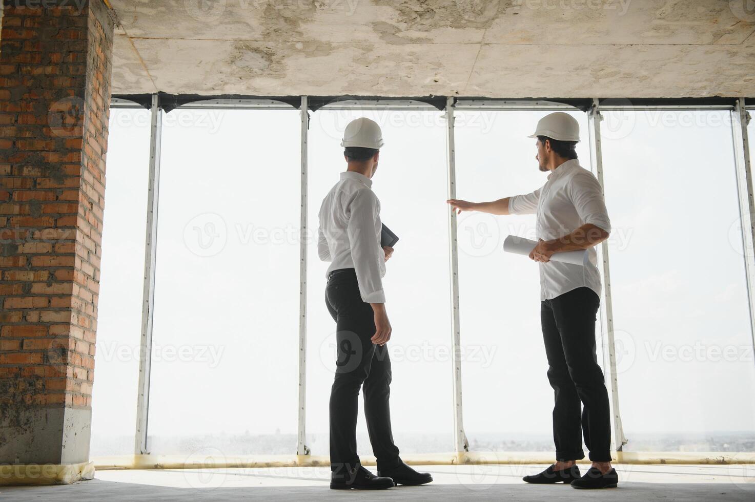 dos especialistas inspeccionar comercial, industrial edificio construcción sitio. real inmuebles proyecto con civil ingeniero foto