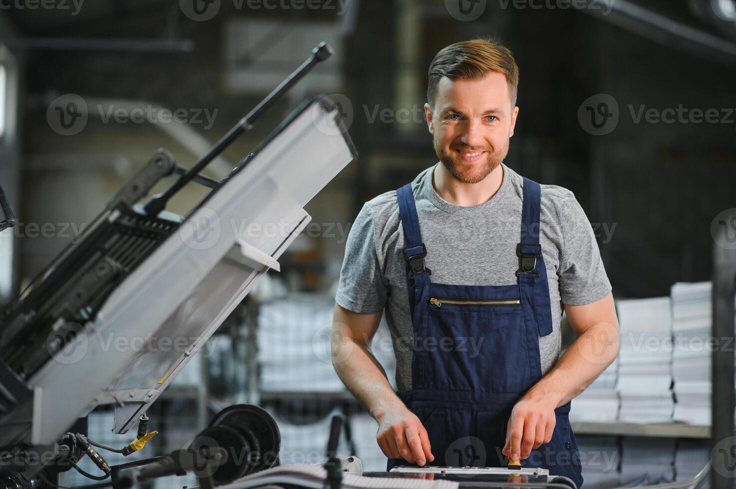 Man working in printing house with paper and paints photo