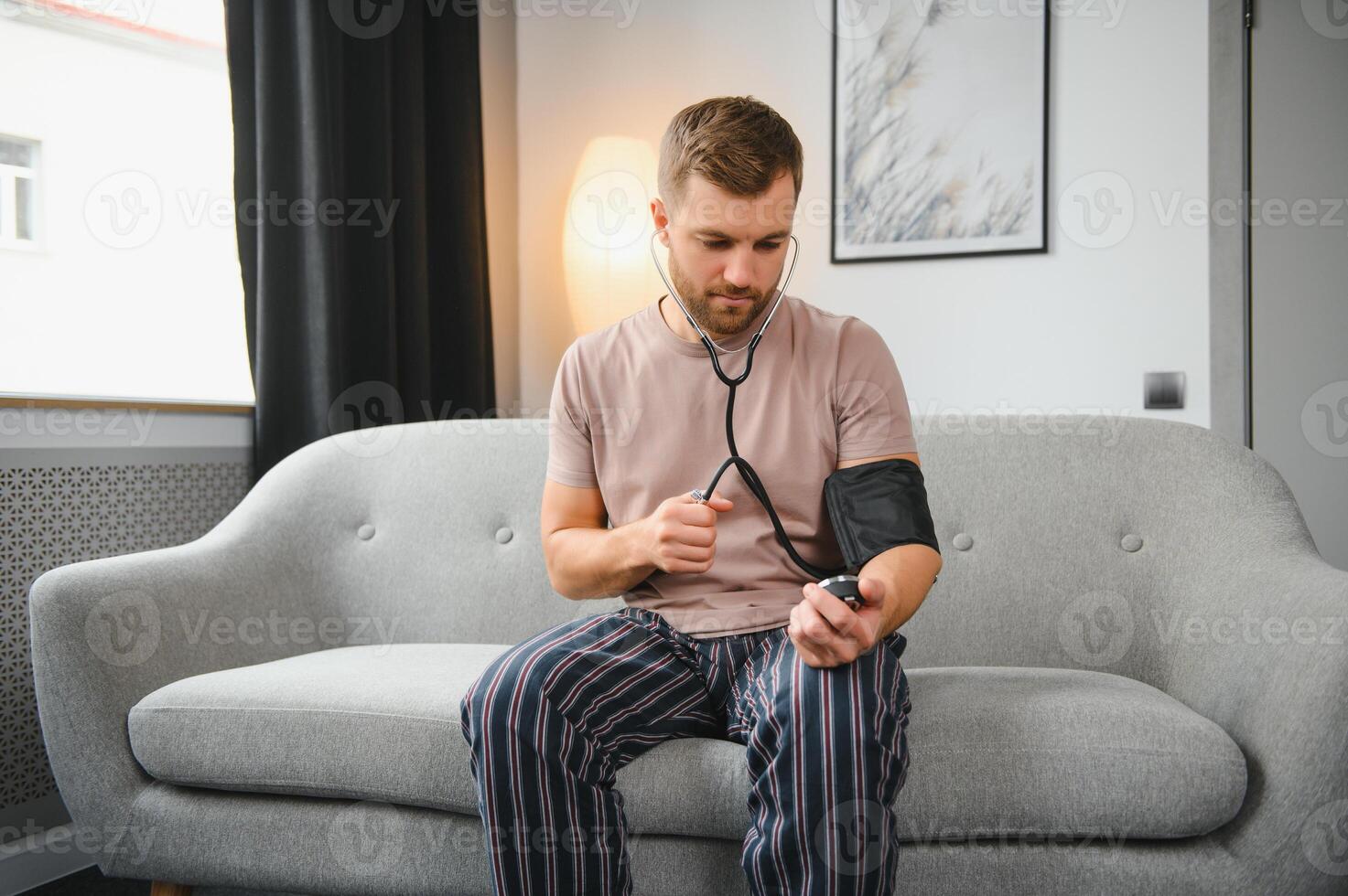 joven hombre medición su sangre presión a hogar foto