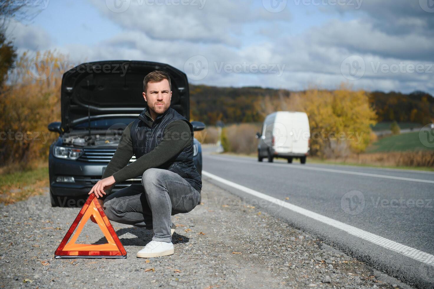 A young man with a black car that broke down on the road,copy space. photo