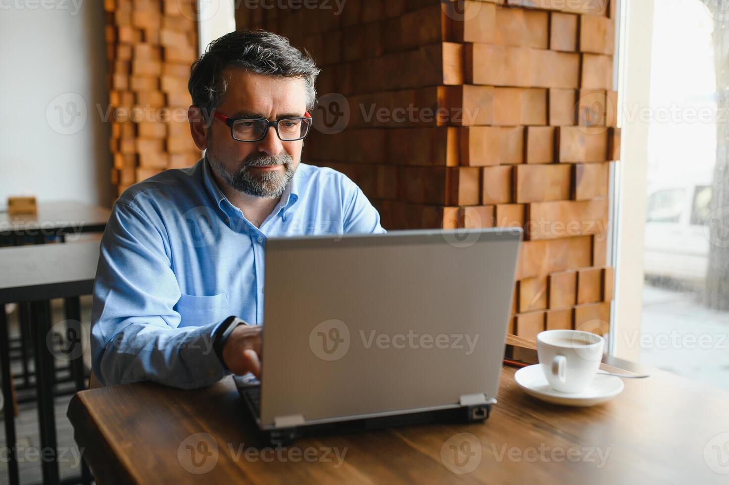 negocio, tecnología y personas concepto , mayor empresario con ordenador portátil computadora Bebiendo café a moderno cafetería. foto