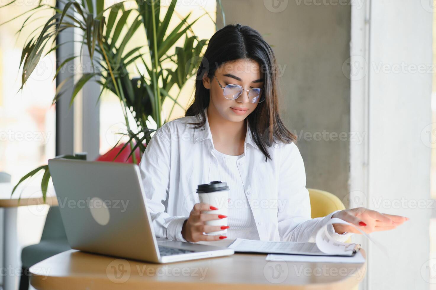 Smiling girl student study online with skype teacher, happy young woman learn language listen lecture watch webinar write notes look at laptop sit in cafe, distant education photo