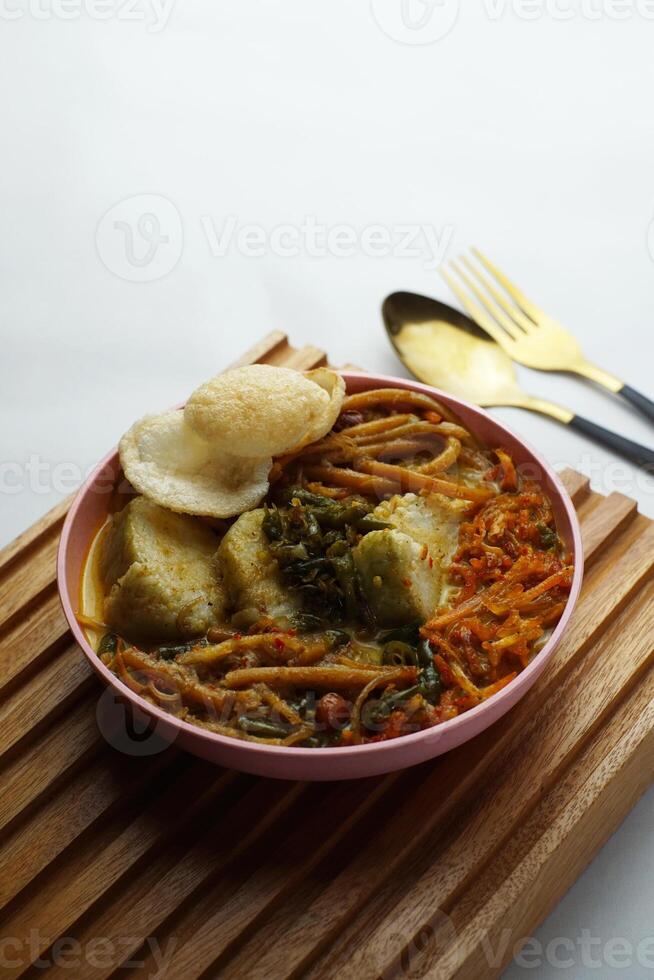 Lontong with curry soup accompanied by fried sweet potatoes chili sauce and noodles photo