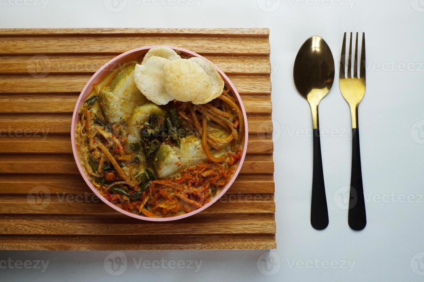 Lontong with curry soup accompanied by fried sweet potatoes chili sauce and noodles photo