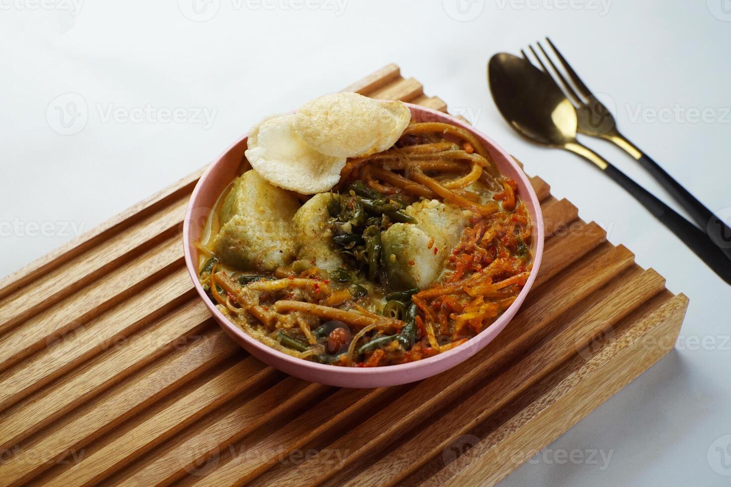 Lontong with curry soup accompanied by fried sweet potatoes chili sauce and noodles photo