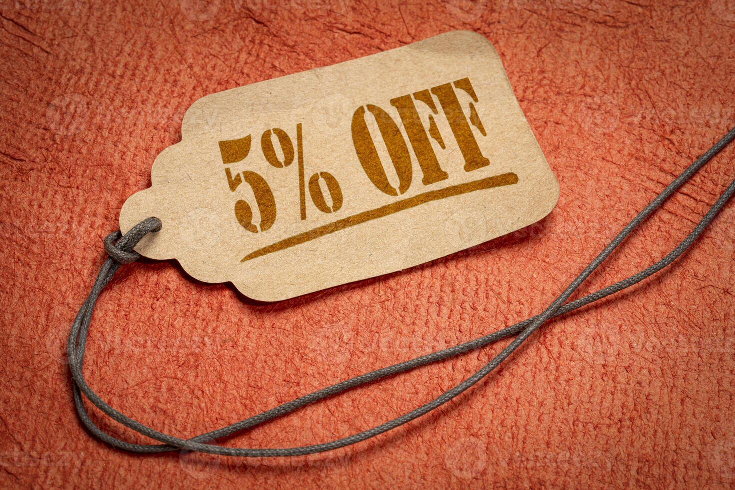 5 percent off - a paper price tag against orange background. sale, discount and shopping concept photo
