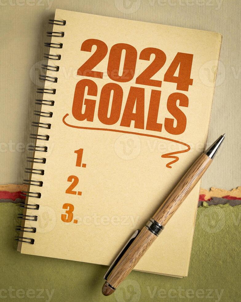 2024 goals list in a notebook with pen, setting New Year goals and resolutions photo