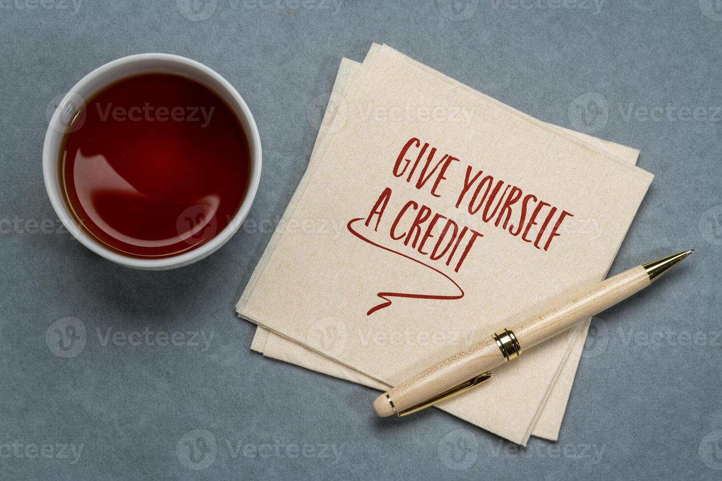 give yourself a credit, inspirational note on napkin, personal development concept photo