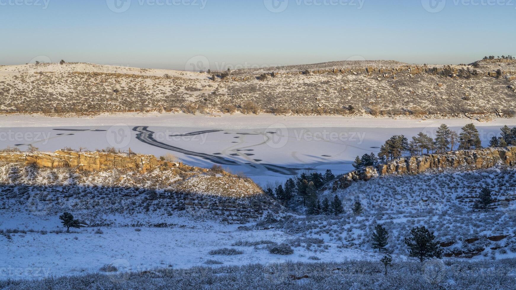 winter scenery in foothills of Rocky Mountains in northern Colorado with frozen Horsetooth Reservoir photo