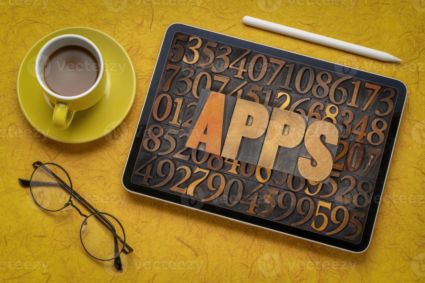 apps, applications, word in vintage letterpress wood type against number background on a digital tablet with coffee -  software concept photo