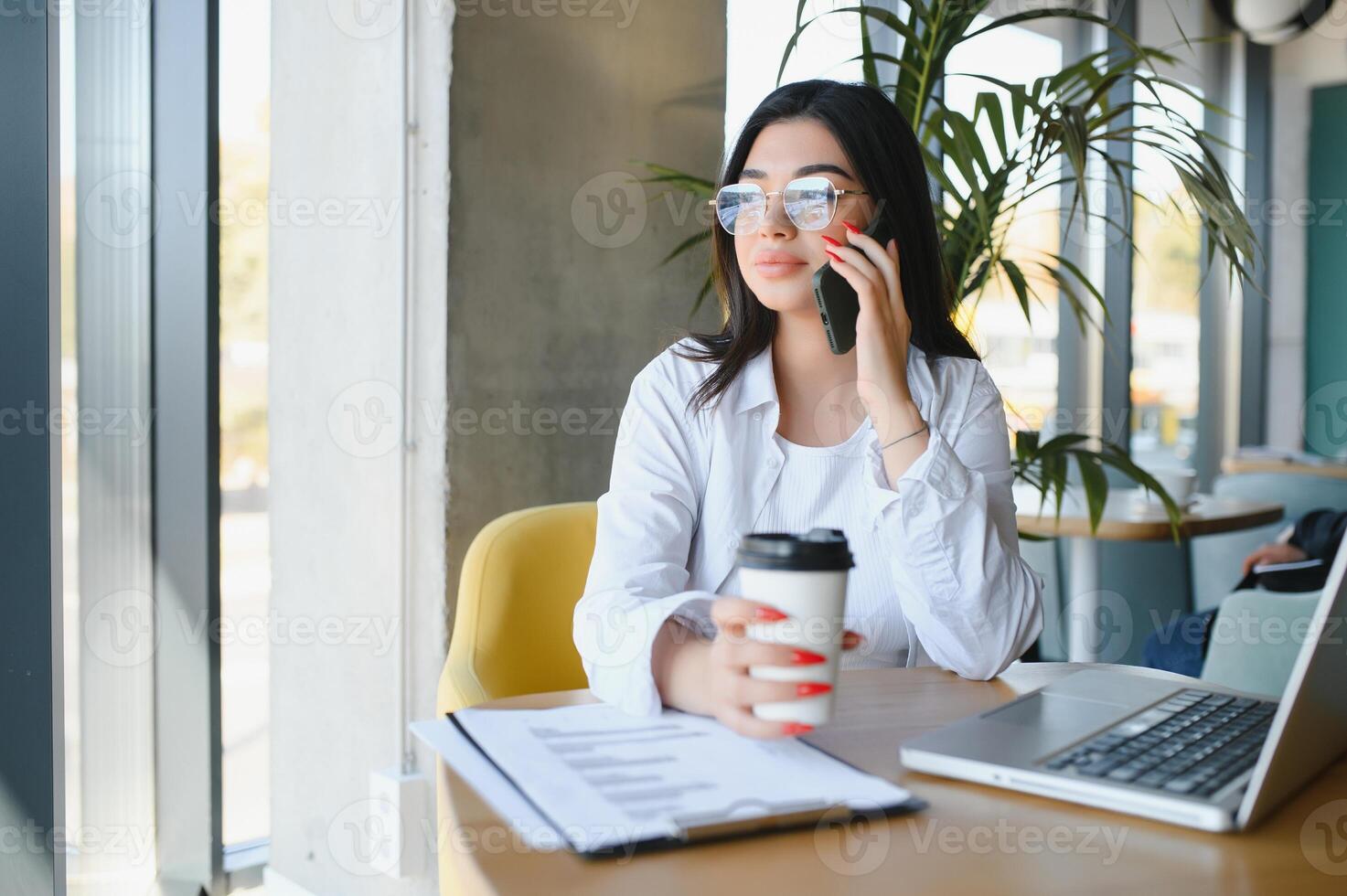 sonriente niña estudiante estudiar en línea con skype maestro, contento joven mujer aprender idioma escucha conferencia reloj seminario web escribir notas Mira a ordenador portátil sentar en cafetería, distante educación foto