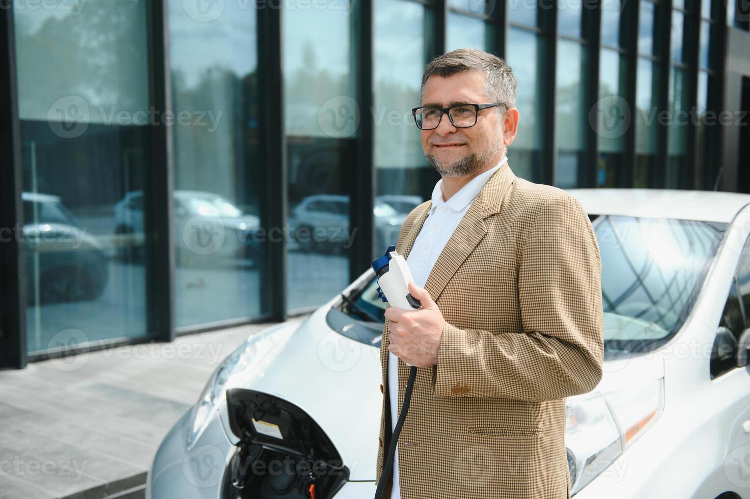 Man holding power connector for electric car photo