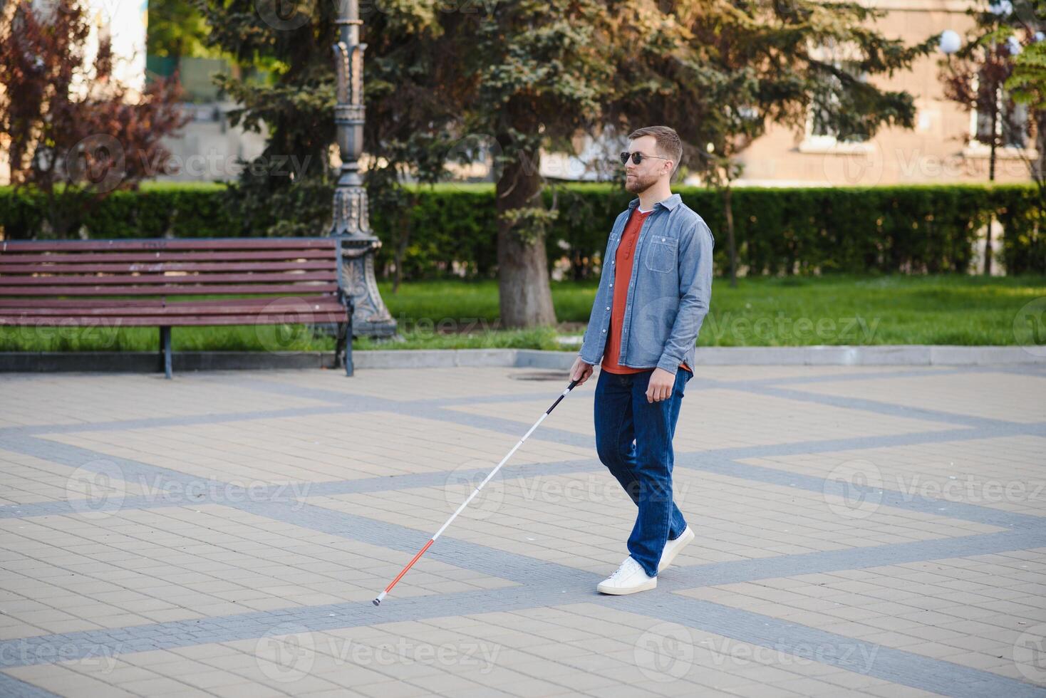 Blind man. People with disability, handicapped person and everyday life. Visually impaired man with walking stick. photo