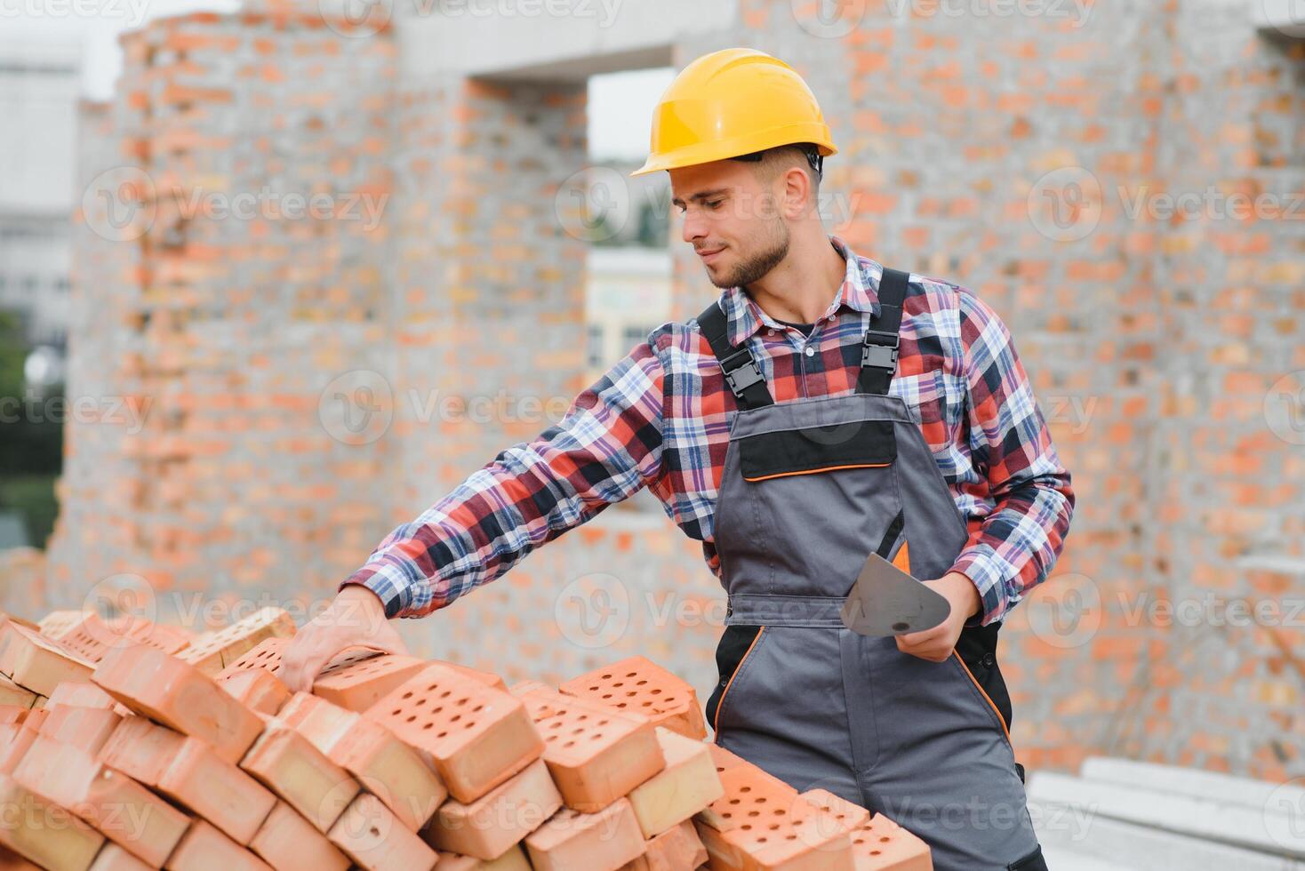 construcción masón trabajador albañil instalando rojo ladrillo con paleta masilla cuchillo al aire libre. foto