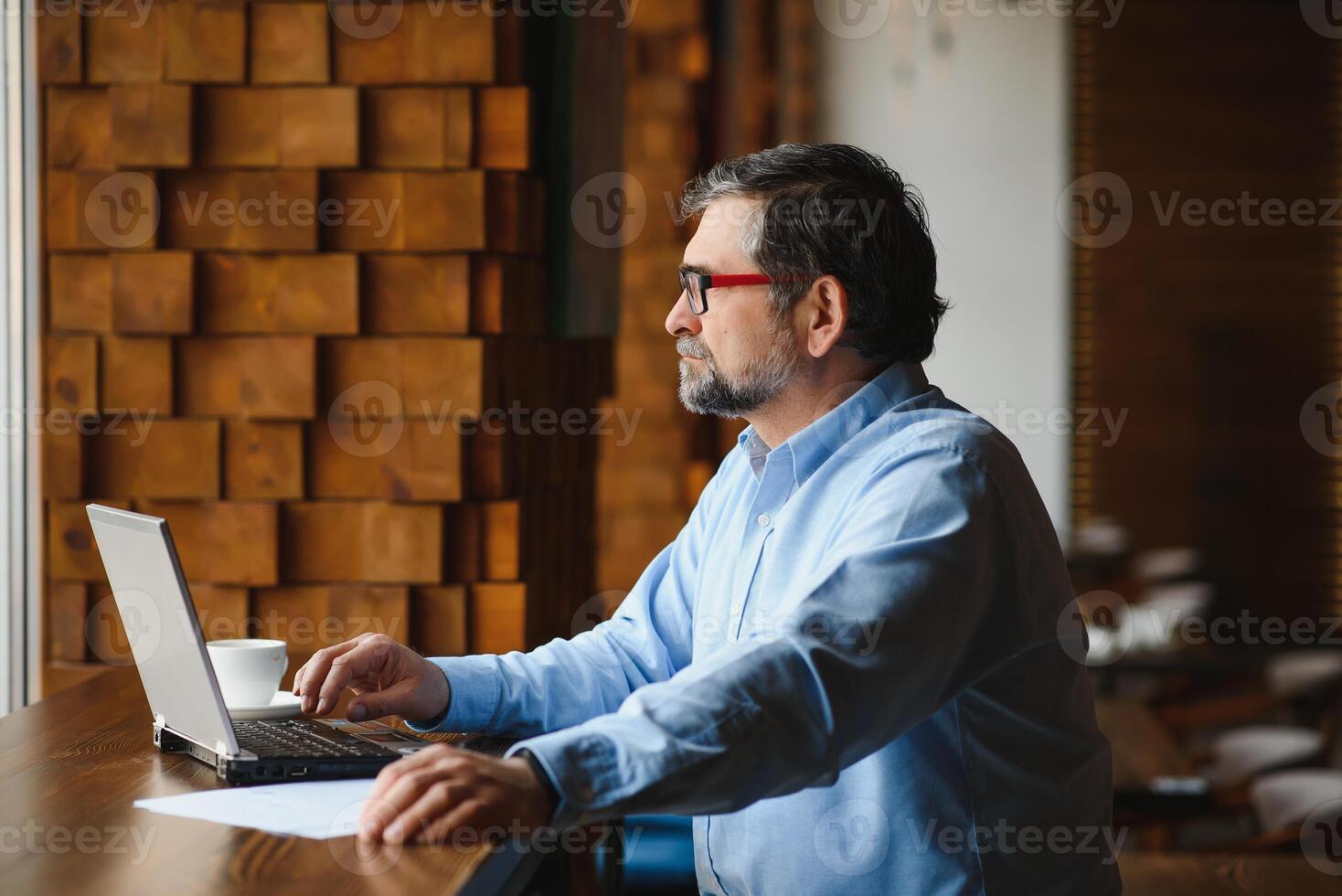 negocio, tecnología y personas concepto , mayor empresario con ordenador portátil computadora Bebiendo café a moderno cafetería. foto