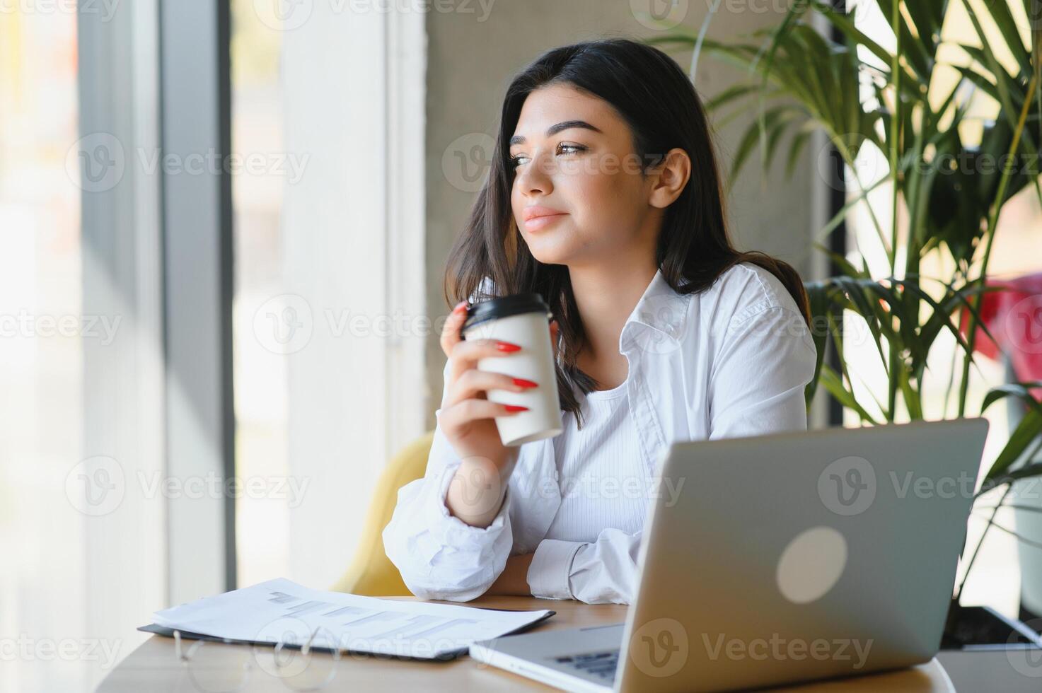 sonriente niña estudiante estudiar en línea con skype maestro, contento joven mujer aprender idioma escucha conferencia reloj seminario web escribir notas Mira a ordenador portátil sentar en cafetería, distante educación foto