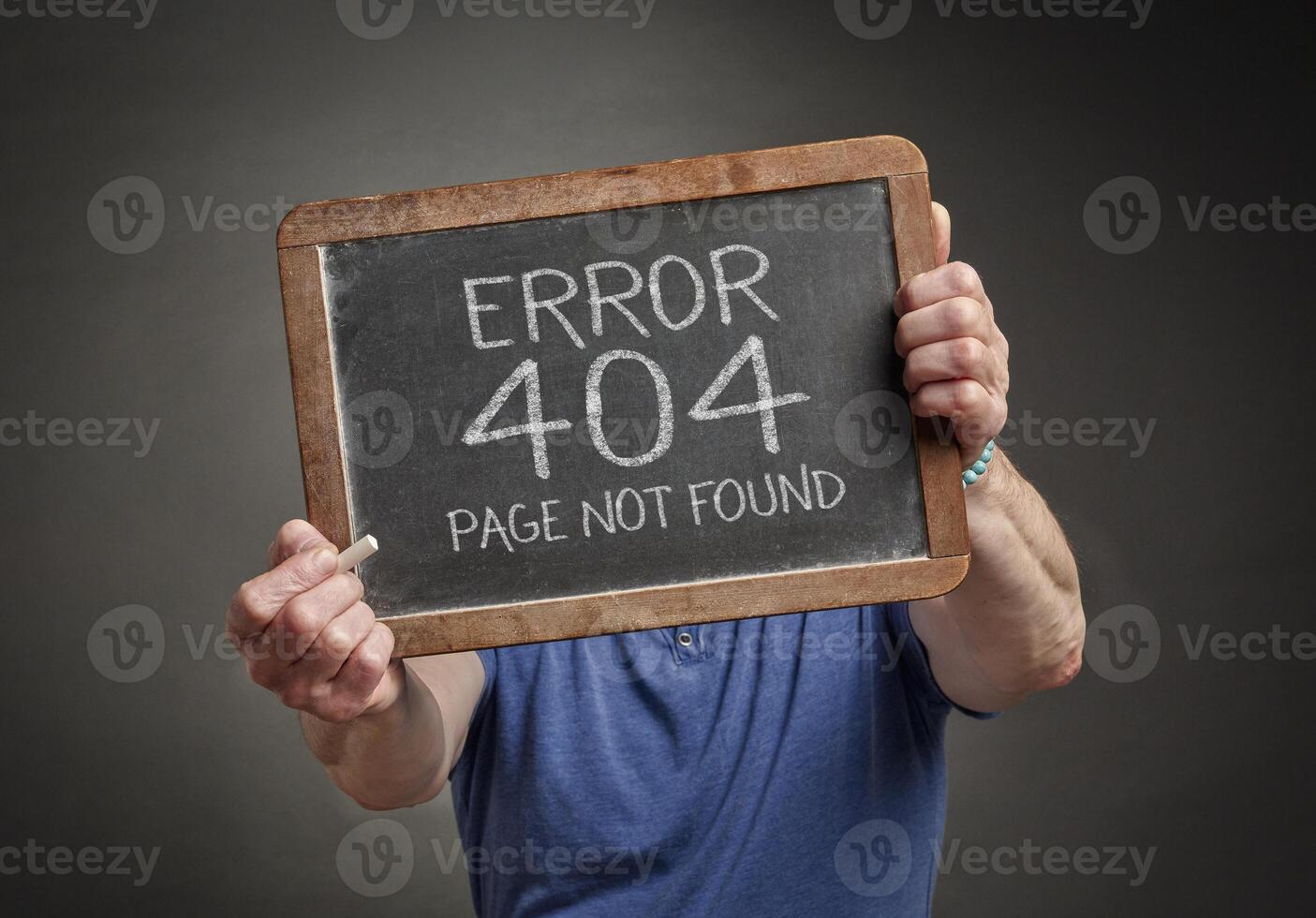 Page not found 404 error - white chalk text on a slate blackboard held by a person, HTTP status code photo