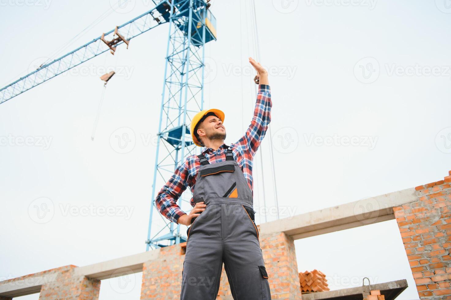 comunicado con grua chico. construcción trabajador en uniforme y la seguridad equipo tener trabajo en edificio. foto