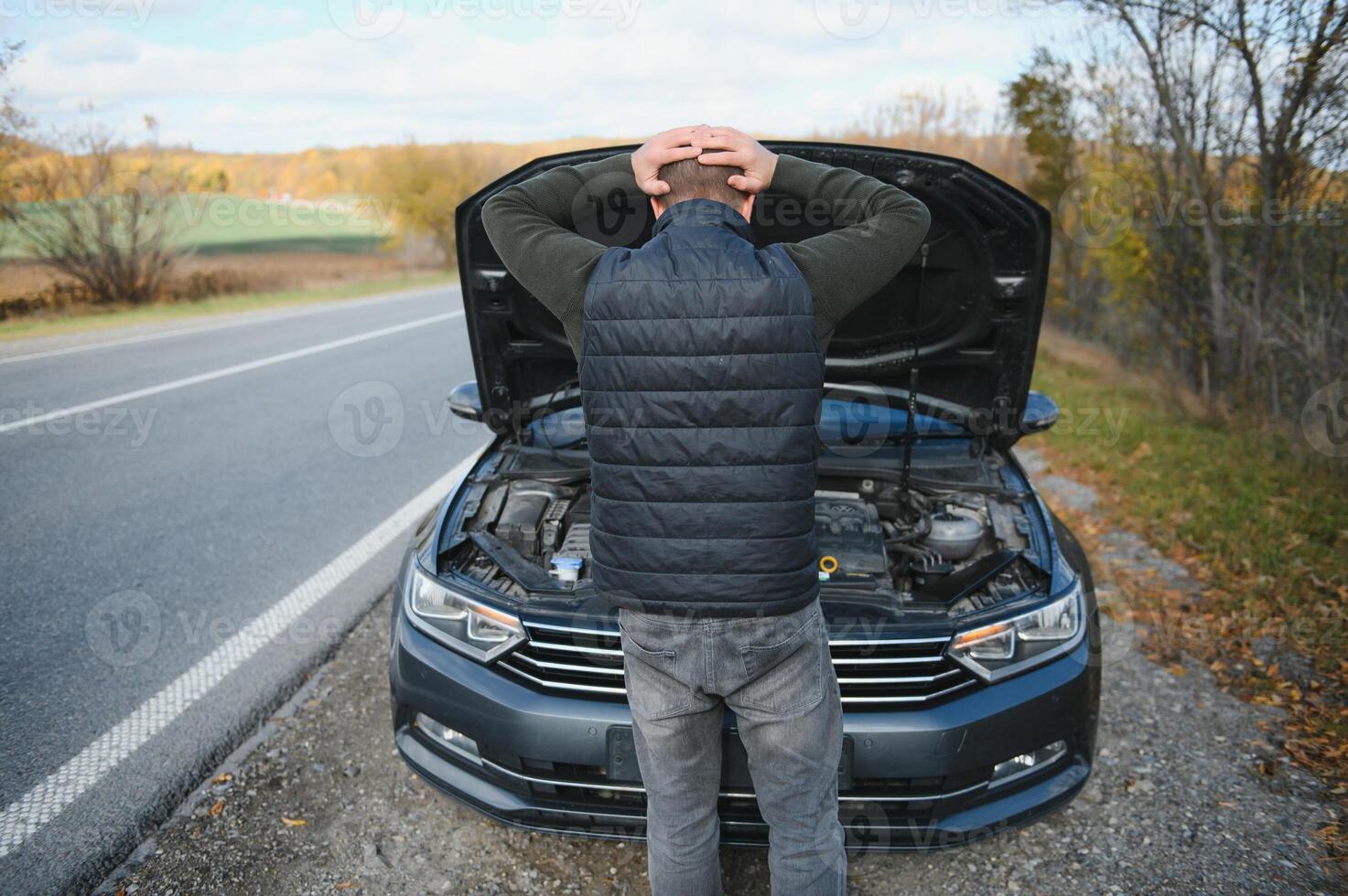 hombre con roto coche en el medio de el la carretera. foto