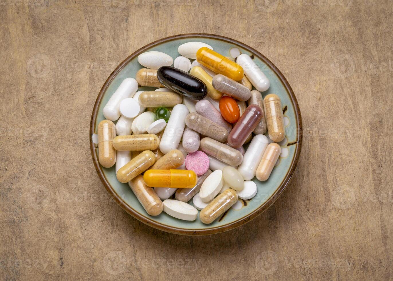 desayuno para un suplemento drogadicto - vitamina pastillas, cápsulas y tabletas en un pequeño cuenco - sano estilo de vida, sobredosis o adiccion concepto foto