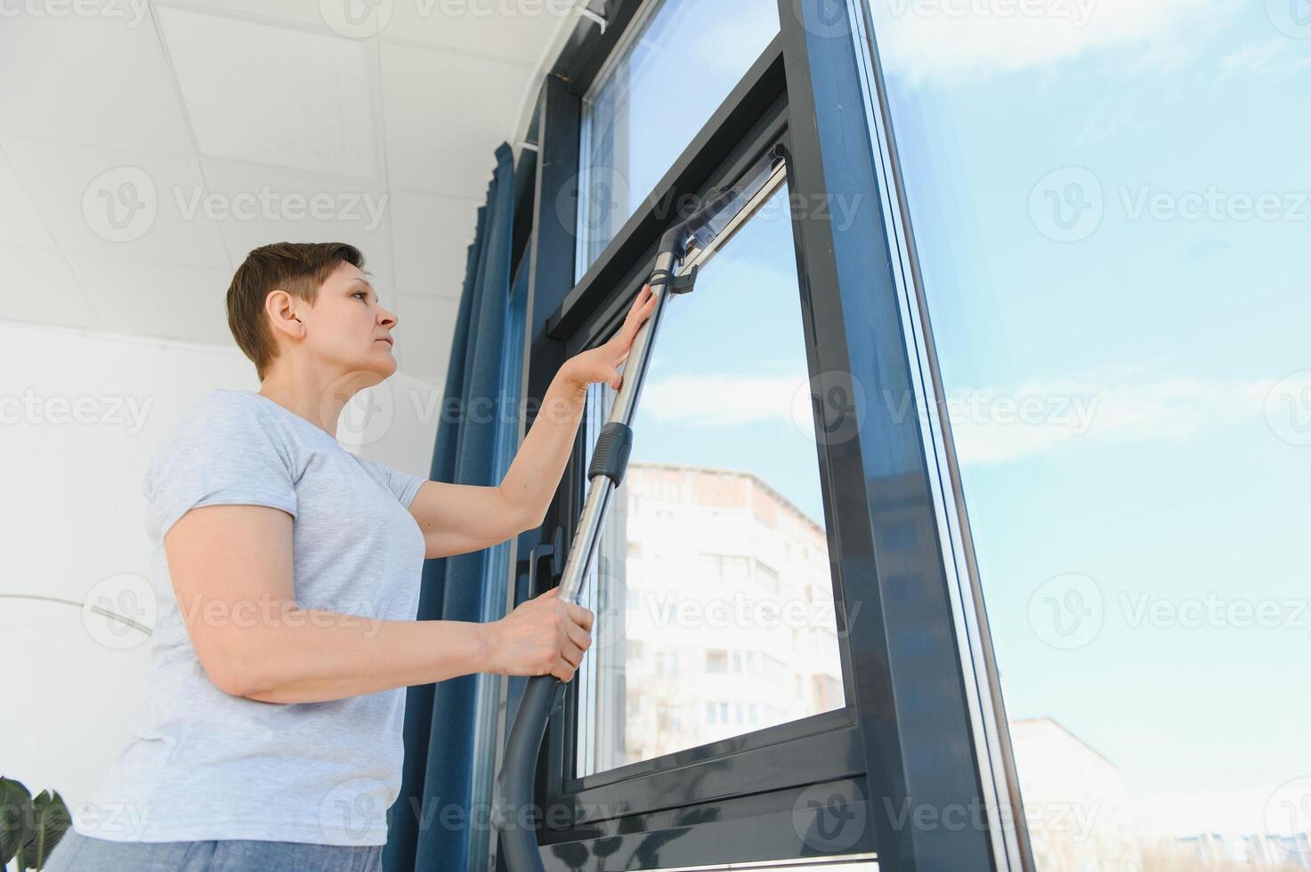 Middle-aged woman cleaning new apartment. photo