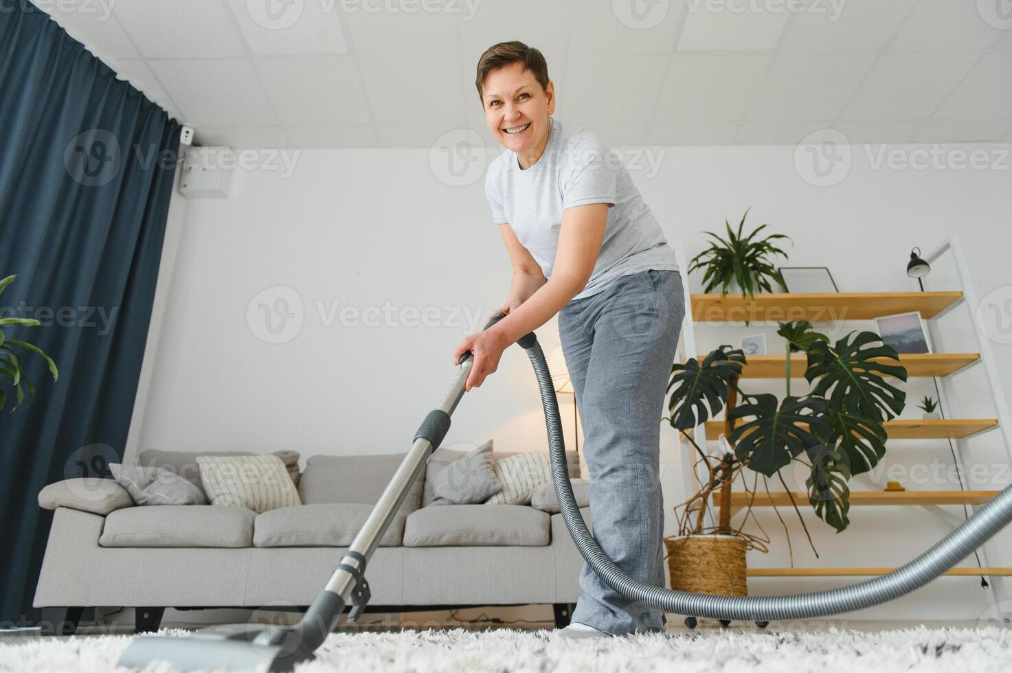 Cleaning concept. woman cleaning carpet with vacuum cleaner. photo