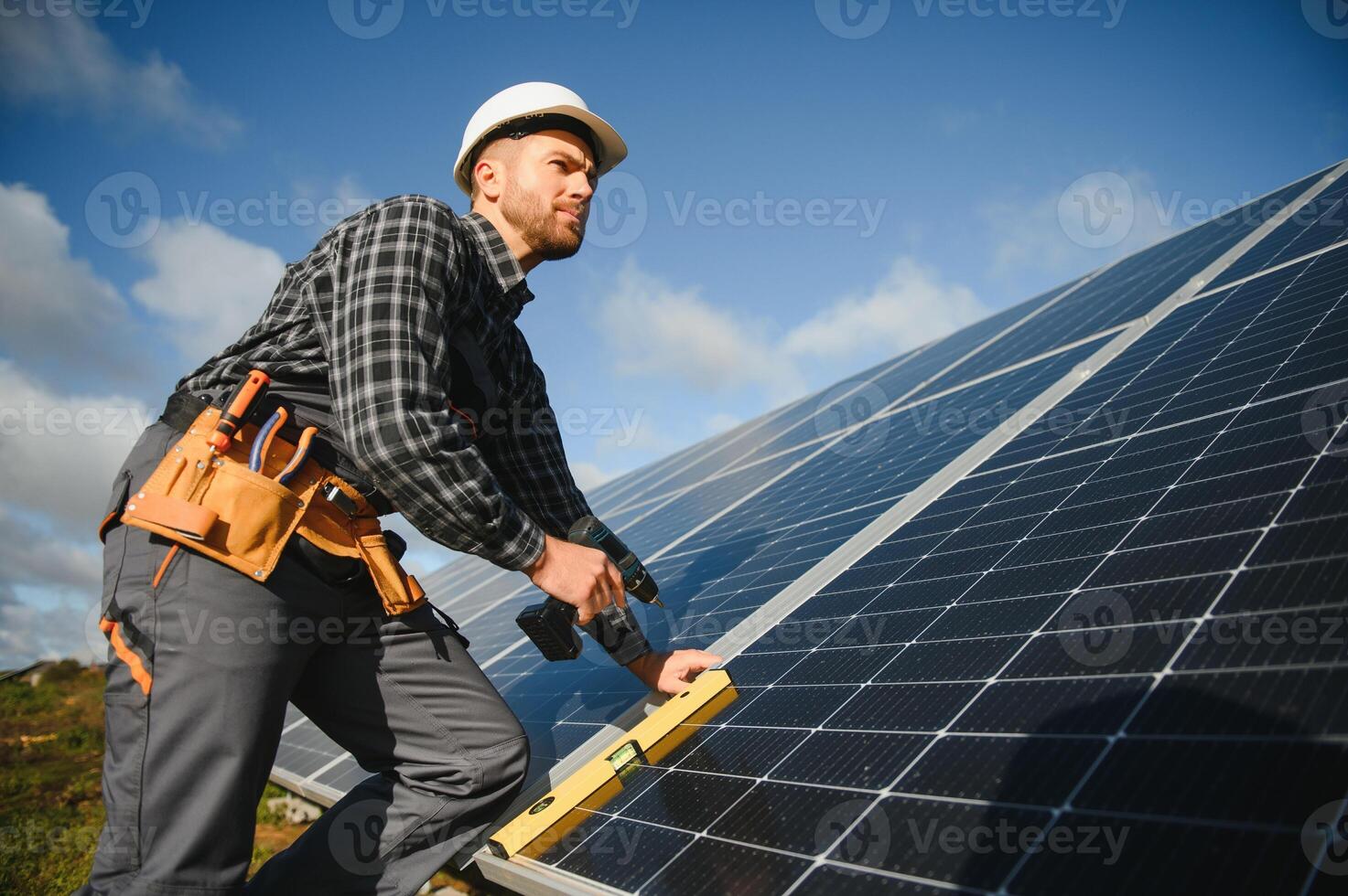 profesional trabajador instalando solar paneles en el metal construcción, utilizando diferente equipo, vistiendo casco. innovador solución para energía resolviendo utilizar renovable recursos. verde energía. foto