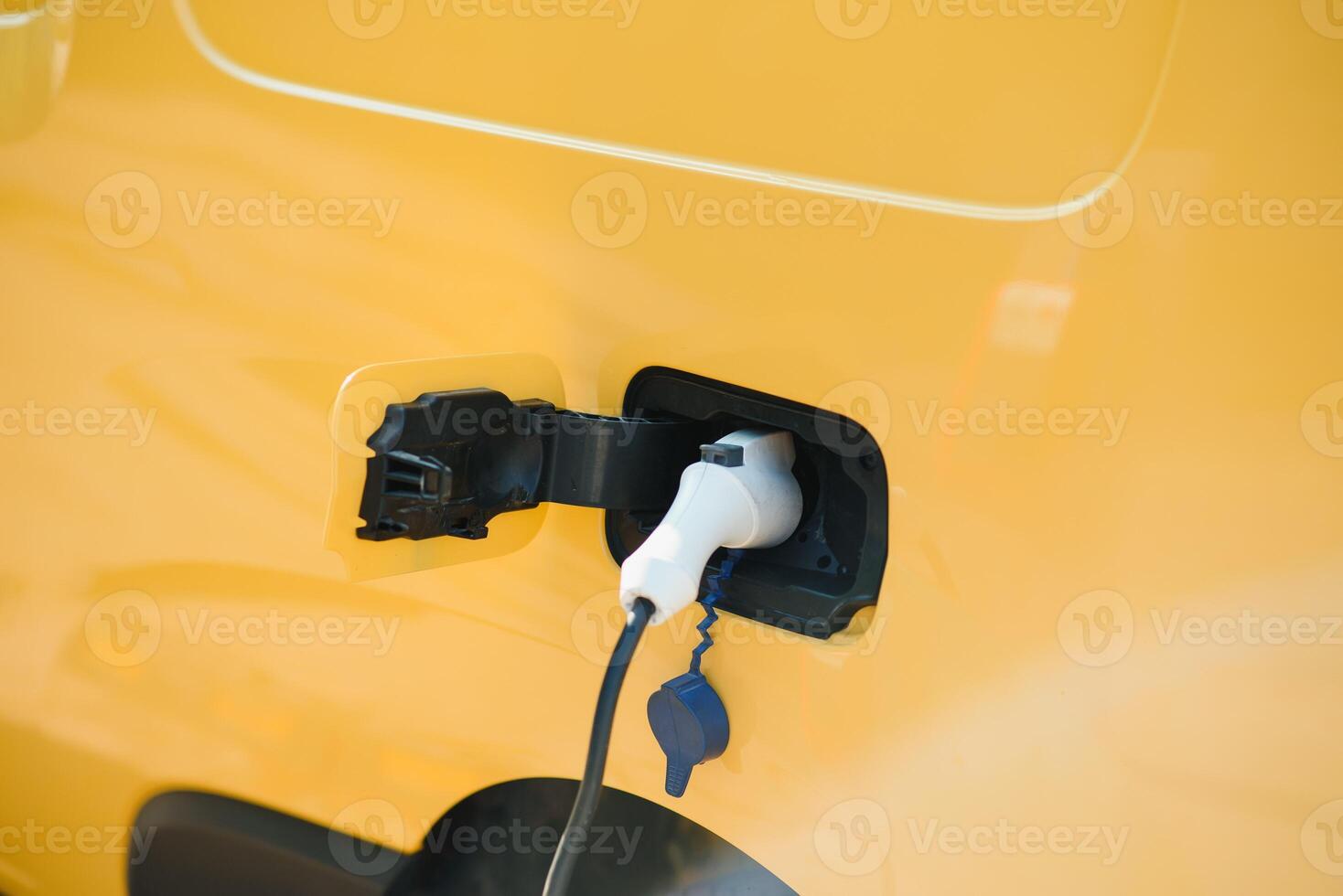 Hansome bearded guy near his new modern electric car at the charging station photo