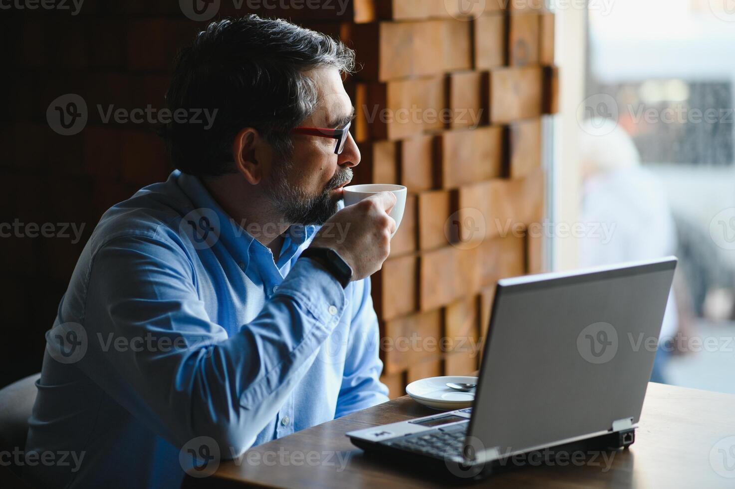 negocio, tecnología y personas concepto , mayor empresario con ordenador portátil computadora Bebiendo café a moderno cafetería. foto