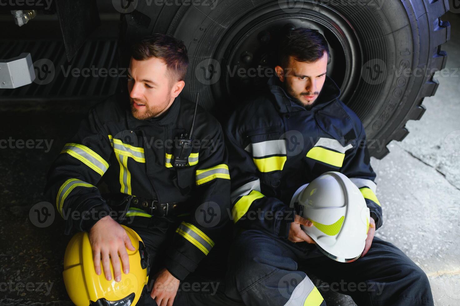 Portrait of two heroic fireman in protective suit and helmet. photo