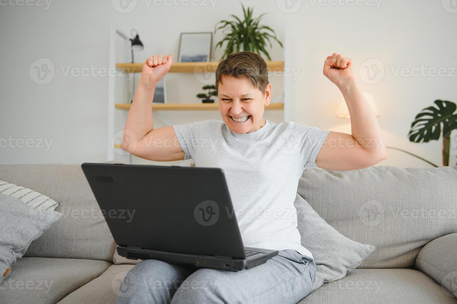 Technology, people and communication concept - Happy senior woman with tablet pc computer having video chat at home. Modern middle-aged 50s grandmother sit relax on couch in living room using laptop. photo