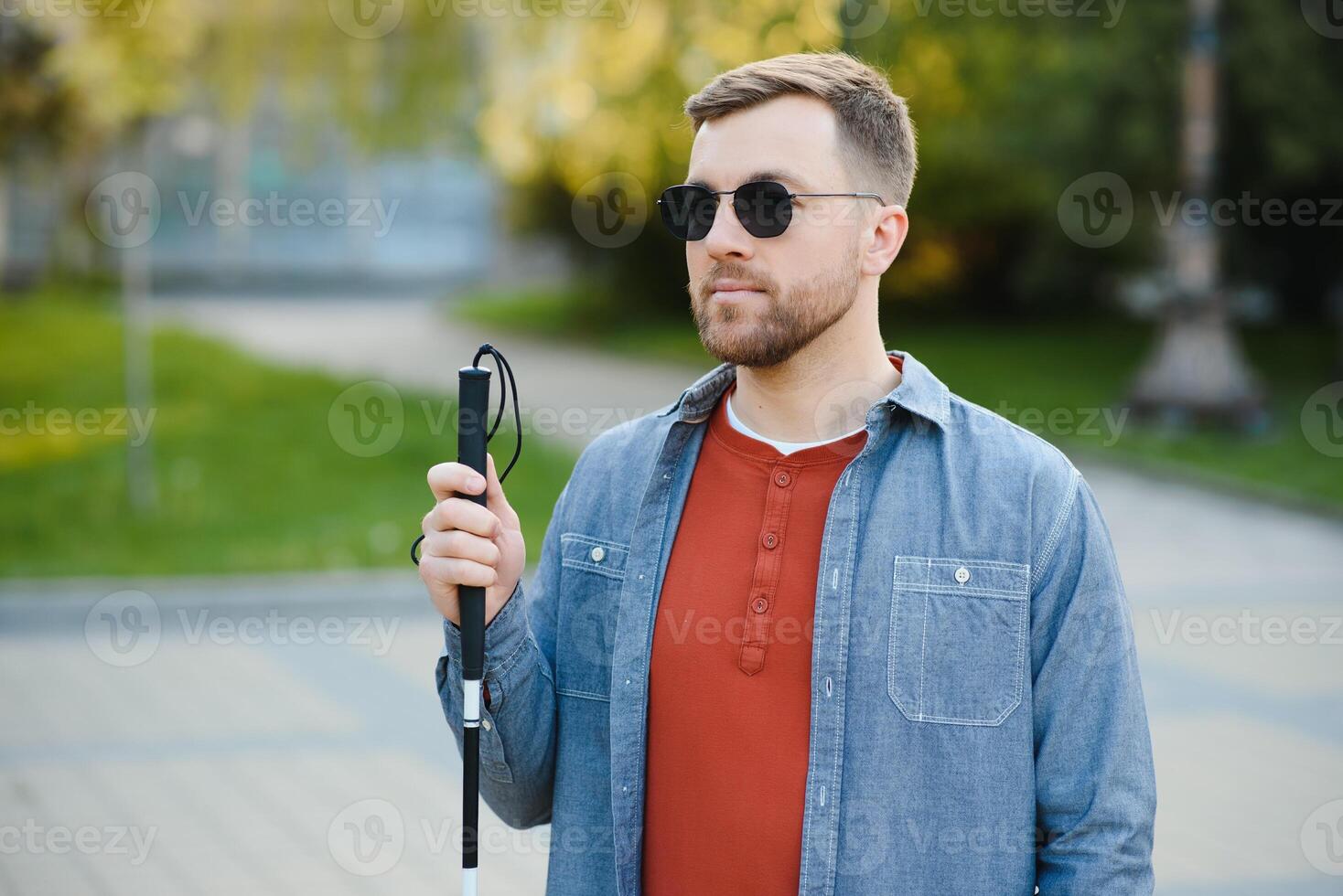 Blind man. People with disability, handicapped person and everyday life. Visually impaired man with walking stick. photo