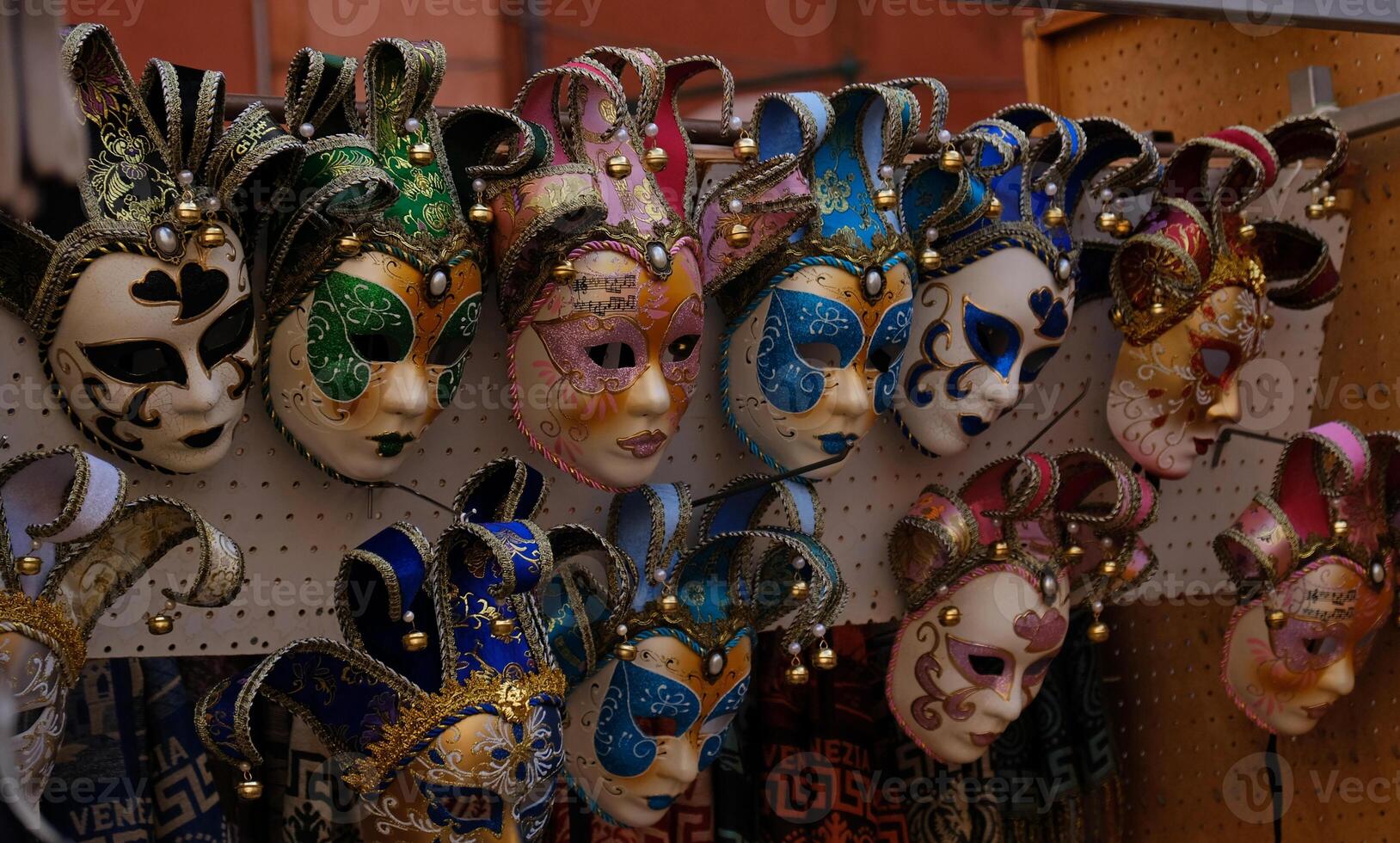 Traditional venetian masks on shelves in souvenirs shop in Venice, Italy. Beautiful carnival masks in variety of colours. Authentic and original Venetian full-face masks for Carnival. photo
