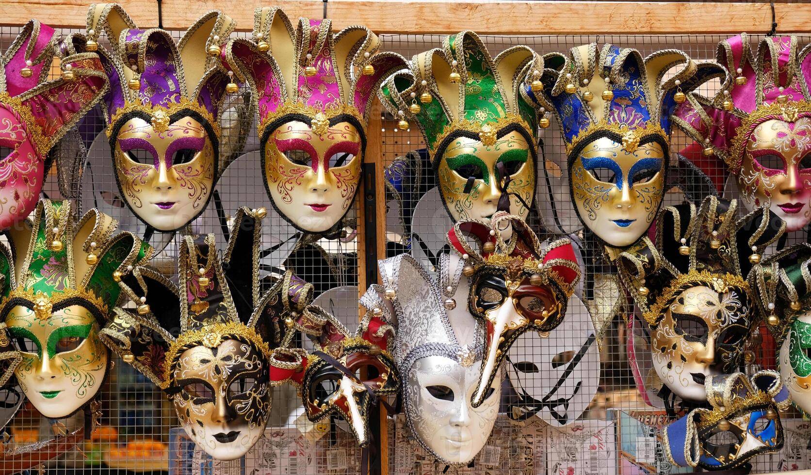 Traditional venetian masks on shelves in souvenirs shop in Venice, Italy. Beautiful carnival masks in variety of colours. Authentic and original Venetian full-face masks for Carnival. photo